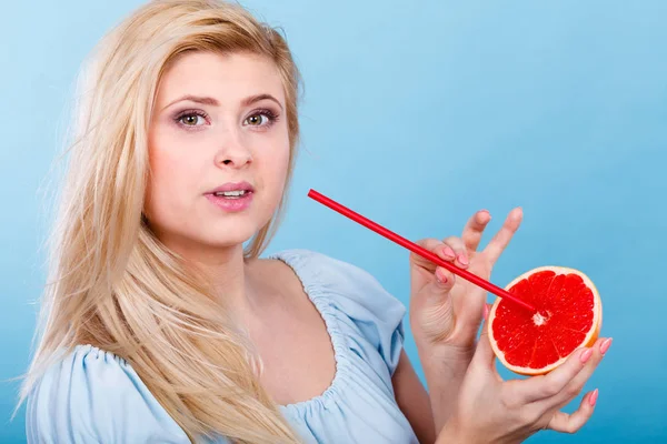 Sağlıklı beslenme, vitamin dolu ferahlatıcı yiyecekler. Sulu meyve suyu içen kadın, kırmızı greyfurt.