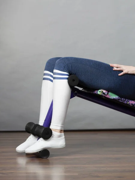 Unrecognizable woman wearing black leggings and long school looking socks training on bench for sit ups at home. Being fit and healthy, stomach muscles workout.