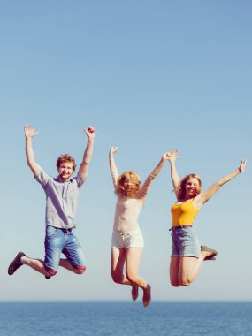 Dostluk özgürlük yaz tatil kavramı. Arkadaşlar çocuk iki kız gökyüzü karşı açık atlama grubu
