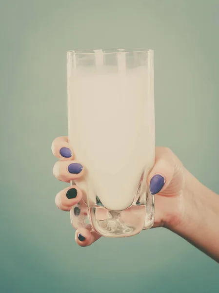 Healthy drinks, good nutrition, dairy products concept. Woman hand holding glass of milk