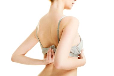 Kadınlık, brafitting, iç çamaşırı, çamaşır grupları kavramı. Çekici ince kadın gri sütyenini çıkar. Beyaz arka plan üzerinde atış stüdyo