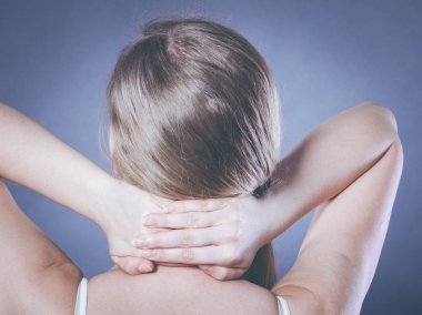 Yorgunluktan sırtım ve omurga hastalığım var. Kadının çok kötü ağrısı var. Kadın ellerini boynuna koyup acıdan kıvranıyor.