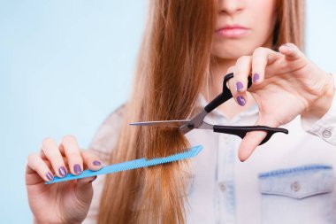 Görüntü değişikliği, yeni imaj. Genç kız tarak ve makas sunar. Kadın stilisti, işe gitmek için gerekli ekipmanı hazırlıyor. Uzun düz, sağlıklı saçları kesiyor..