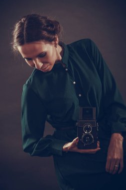 Kadın retro tarzı uzun siyah elbise alarak resim ile eski fotoğraf makinesi, vintage fotoğraf