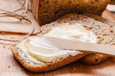 Natürmort taze kepekli ekmek tereyağı ve bal rustik ahşap masa arka plan ile