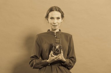 Kadın retro tarzı uzun siyah elbise alarak resim ile eski fotoğraf makinesi, vintage fotoğraf
