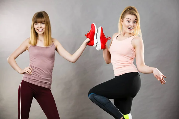 Deux Femmes Souriantes Heureuses Présentant Des Chaussures Rouges Pour Entraîneurs — Photo