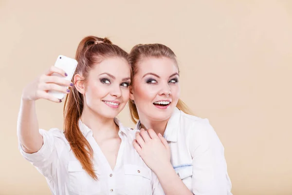 楽しい結合 Selfie のコンセプトです 姉妹や親友 スマート フォンのカメラでセルフ写真を撮る つの学生ブロンドの女の子は 顔に面白い楽しい 正の感情を持っています — ストック写真