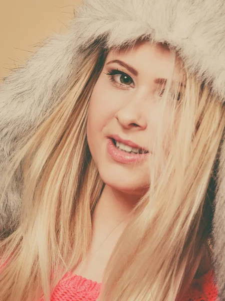 Accessories and clothes for cold days, fashion concept. Happy blonde woman in winter warm furry hat in russian style