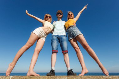 Dostluk mutluluk yaz tatil kavramı. İn arkadaş grubu ile tam uzunlukta çocuk iki kız açık eğleniyor. Gökyüzü karşı geniş açılı görünüş