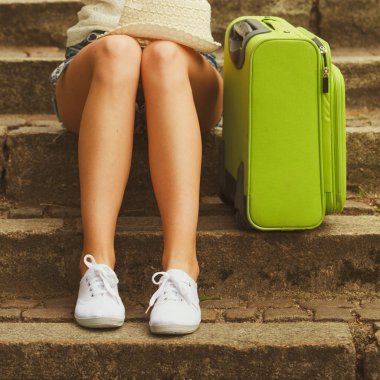 Seyahat ve seyahat. Kadın turist vücudunun bir parçası. Yeşil valizli kız ziyarete geliyor..