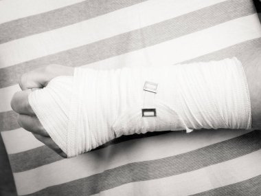 Kırık ve çıkık bir kavram. Bölümü beden erkek elinde bandaj ile. Genç adam acı palm kol için yararlı ilaç.