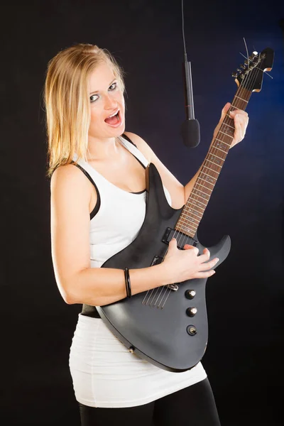 唱歌的概念 音乐才女弹电吉他和唱歌在工作室 黑色背景 — 图库照片