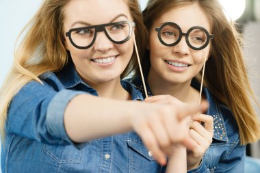 Dostluk, insan ilişkileri kavramı. İki mutlu kadın arkadaş ya da bir yere işaret kot gömlek giymiş kız.