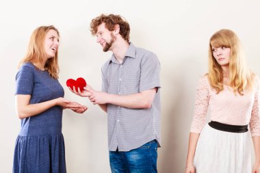 Kıskançlık ve ihanet kavramı. Terk edilmiş sevilmeyen kız mutlu sarılma çift üzerinde izliyor. Üçgen ilişki.