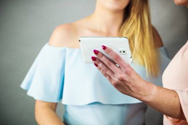 Fotoğraf çekimi veya sosyal ortamda bir şey ararken beyaz smartphone tutan kadın. Yeni teknoloji ve modern cihazlarla kavramı.