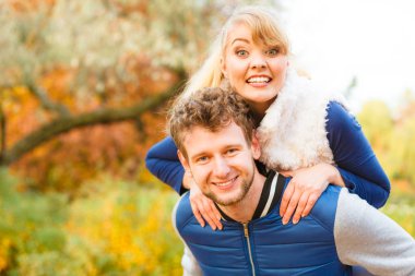 Sağlıklı bir ilişki ve kavram çıkıyor seviyorum. Sonbahar park kadına aşık çift eğleniyor, veren adam omzunda. Genç Yetişkin kız ve erkek arkadaşı mutlu sarılma.