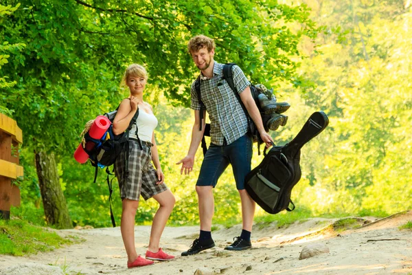 夏の時間を一緒に楽しむ 森の道日当たりの良い田舎でギターバックパックトランプで若いカップルをハイキング — ストック写真