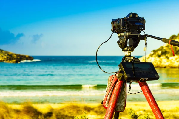 Professional camera taking film video or shooting images pictures of sea coastline in Greece Peloponnese