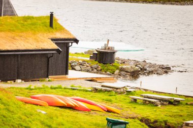 Lodge Haukeliseter Fjellstue, evler çatı üzerinde büyüyen çimen ile. Birçok Kano açık, Norveç göl manzara.