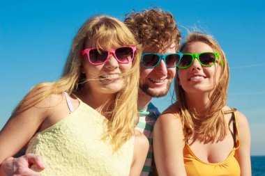 Dostluk mutluluk yaz tatil kavramı. Arkadaşlar çocuk iki kız açık gökyüzü karşı neşe neşeli ruh eğleniyor renkli güneş gözlüğü grubu.