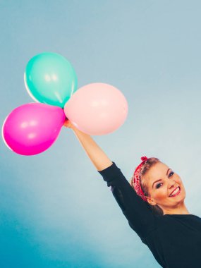 Sevinç eğlence ve özgürlük kavramı. Topları uçan renkli lateks balonlar ile sarışın gülümseyen kadın. Retro moda tarz kız portre.