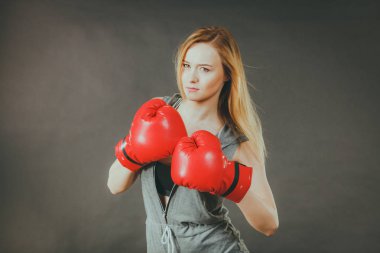 Şehvetli genç kadın, sarışın çekici kız kırmızı yumruk boks eldiven giyiyor. Spor fitness ve güç kavramı.