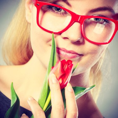 İncelik ve incelik kadın. Bahar çiçek genç güzel kadın. Narin kız kırmızı güzel Lale ile gözlük Güzellik Portresi.