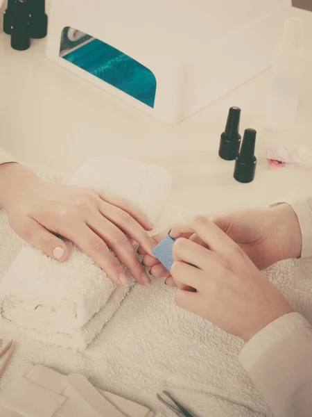 Woman hand on towel, beautician file nails. Beauty wellness spa treatment, manicure concept