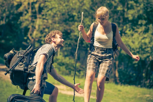 Macera, turizm, yaz tatilinin tadını çıkarmak gitarlı genç bir çiftin orman yolunda gezintisi güneşli kırsal kesimde.
