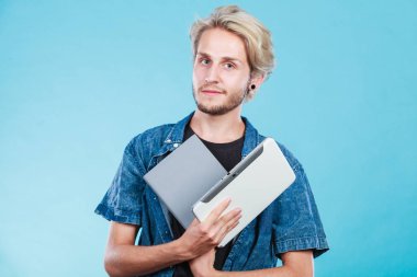 EBook okuyucu ve kitap tutan erkek öğrenci. Modern eğitim teknolojisi ve geleneksel yol yöntemi arasında seçim. Dijital tablet pc ve ders kitabı ile genç adam.