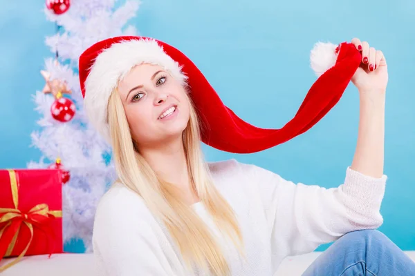 サンタクロースの赤い帽子を身に着けている幸せな若い女性クリスマスプレゼントや休日について考える — ストック写真