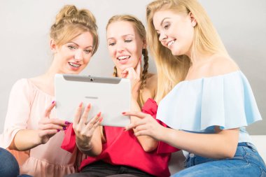 Eğleniyor koltukta oturan kadınlar akıllı dijital pc tablet modern cihaz kullanarak internette sörf