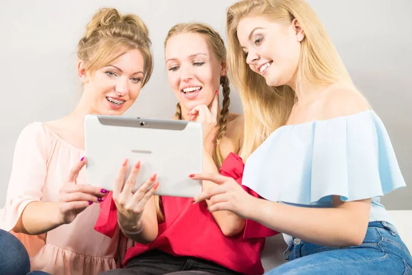 Eğleniyor koltukta oturan kadınlar akıllı dijital pc tablet modern cihaz kullanarak internette sörf