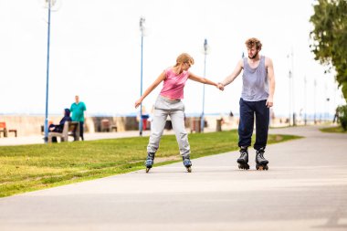 Aktif genç insanlar arkadaş eğitim paten açık uygun. Kadın ve erkek çift zevk spor sürme elele.