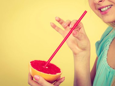 Sağlıklı beslenme, vitamin dolu ferahlatıcı yiyecekler. Meyve suyu içen bir kadın, kırmızı greyfurt.