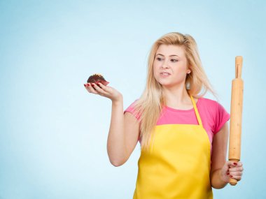 Lezzetli tatlılar tatlılar ev concept, pişirme. Lezzetli çikolatalı kek ve oklava sarı önlük giyen tutan kadın.