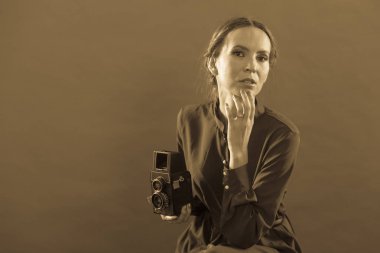 Kadın retro tarzı uzun siyah elbise alarak resim ile eski fotoğraf makinesi, vintage fotoğraf