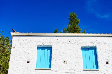 Tipik Yunan mimarisi konsepti ayrıntılarıyla anlatıyor. Yunanistan 'da evdeki mavi pencere panjurları.