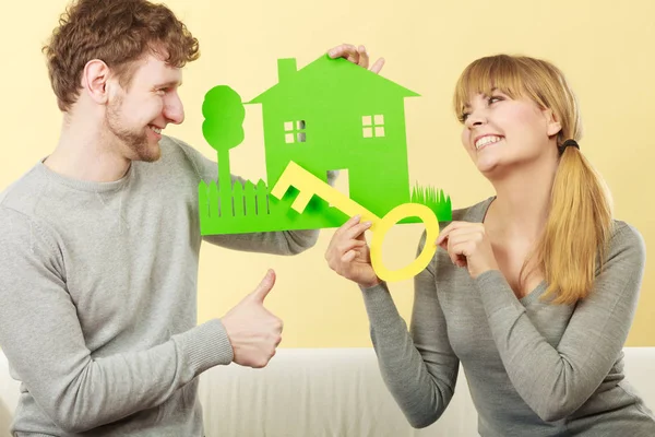 New sweet home. Just married happy couple receive the symbolic key for their new paper house.