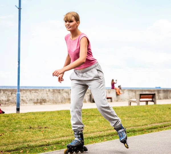 Outdoors activities sport and hobby.Wellbeing and exercising. Girl have fun riding rollerblades in park spending free time in summer.