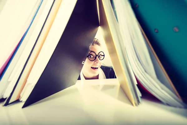 Happiness and satisfaction from working. Young positive happy blonde accountant at work. Crazy lovely woman surrounded of piles of colorful binders.