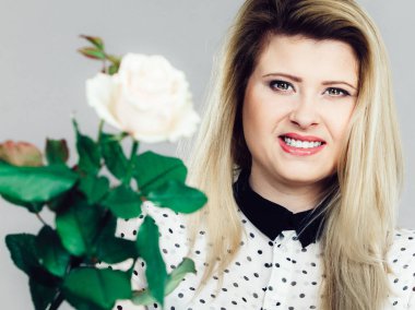 Beyaz gül tutan mutlu pozitif kadın. Sevgililer ve kadının gün hediye fikirleri kavramı.