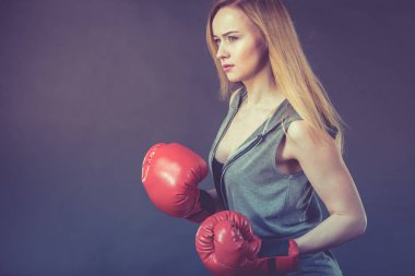 Şehvetli genç kadın, sarışın çekici kız kırmızı yumruk boks eldiven giyiyor. Spor fitness ve güç kavramı.