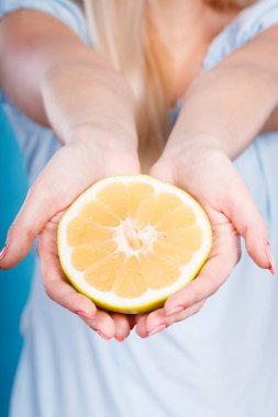 Erkek sarı greyfurt narenciye meyve yarısı closeup eller. Sağlıklı bir diyet kilo kaybı kavramı.