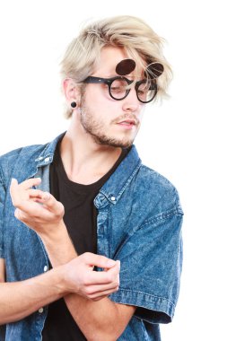 Erkek moda, Aksesuar, saç modeli, kavram modelleme. Sanatsal hipster adam giyen kot elbise ve eksantrik gözlük aşağı, seyir el jest, stüdyo izole vurdu