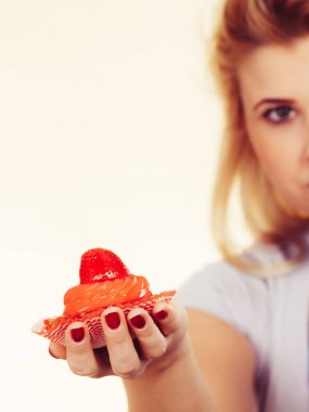 Şekerler, abur cuburlar, diyet kavramının cazibesi. Bir kadın lezzetli bir kek tutuyor.