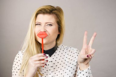 Sahte dudaklar tutan mutlu kadın eğleniyor. Fotoğraf ve karnaval komik aksesuar konsepti.