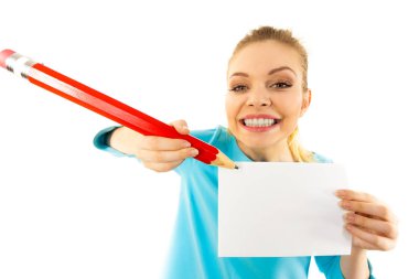 Genç bir kadın büyük boy kalem kullanarak kağıt parçasına notlar yazıyor..