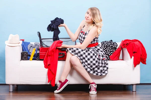 パッキング問題 旅行の概念の中に必要なもの スーツケースにパックする服を選ぶ休暇の準備 ソファーに座っていた女 — ストック写真